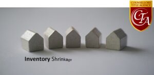Four small wooden house models arranged in a row with the text 'Story Shrinkage'.