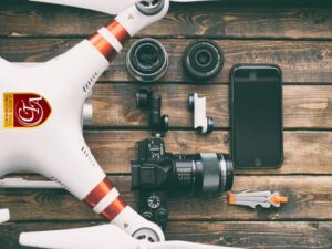 Drone, camera, and tech gear neatly arranged on a wooden surface.