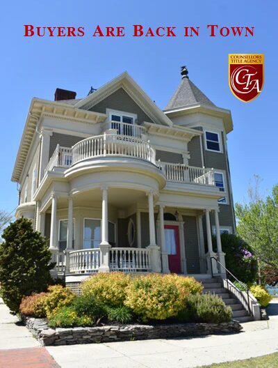 Elegant Victorian-style house with a rounded balcony and turret under a clear blue sky.