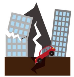 A car is trapped in a cracked road between two damaged buildings.