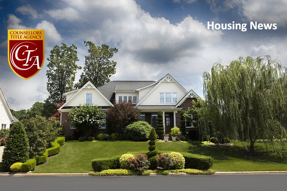 Beautiful suburban house with well-manicured lawn under a cloudy sky.
