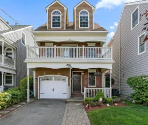 A charming two-story house with a white balcony and garage.