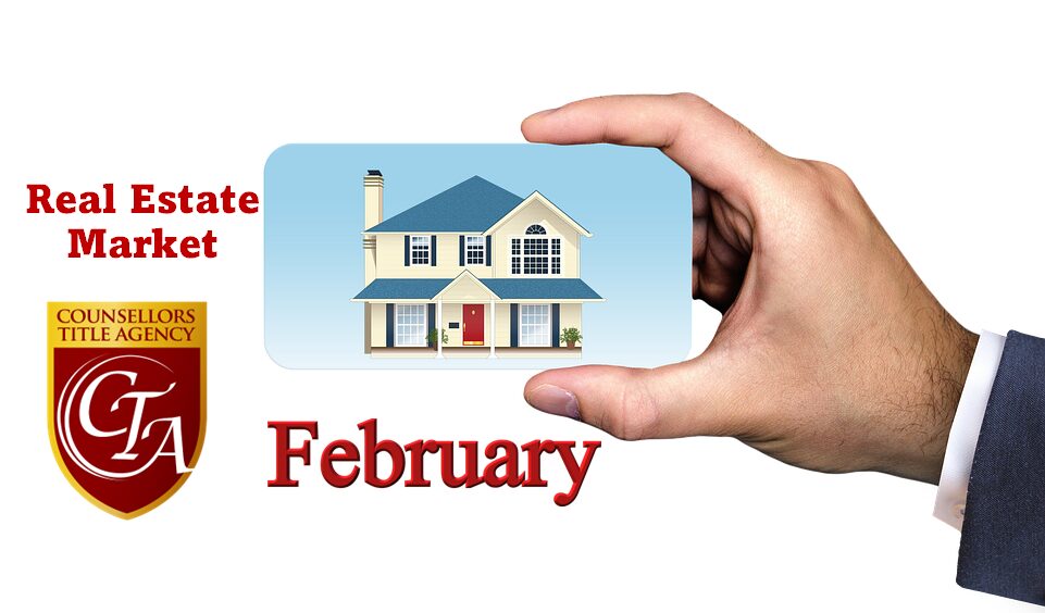 Hand holding a house card with February text.