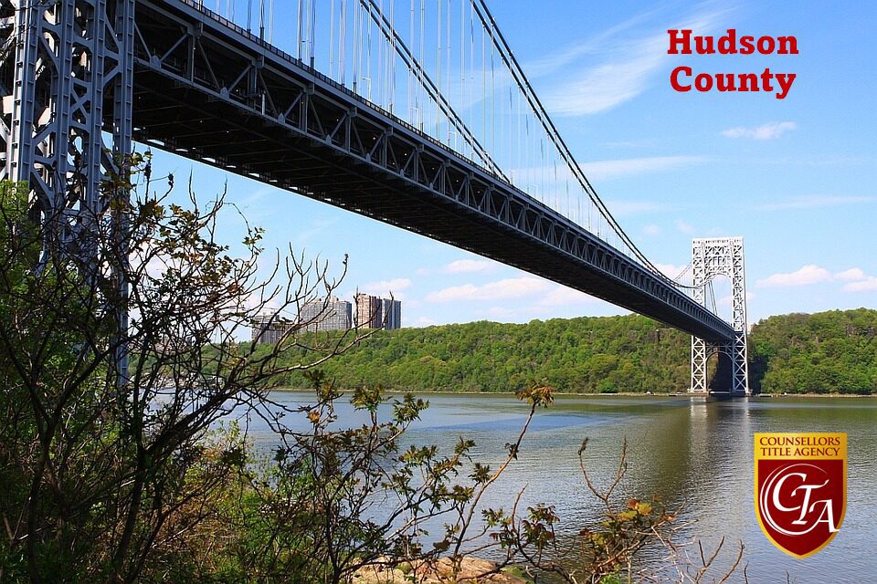 View of the George Washington Bridge over the Hudson River with greenery and cityscape.