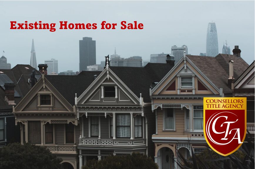 Row of colorful Victorian homes under a cloudy sky in San Francisco.