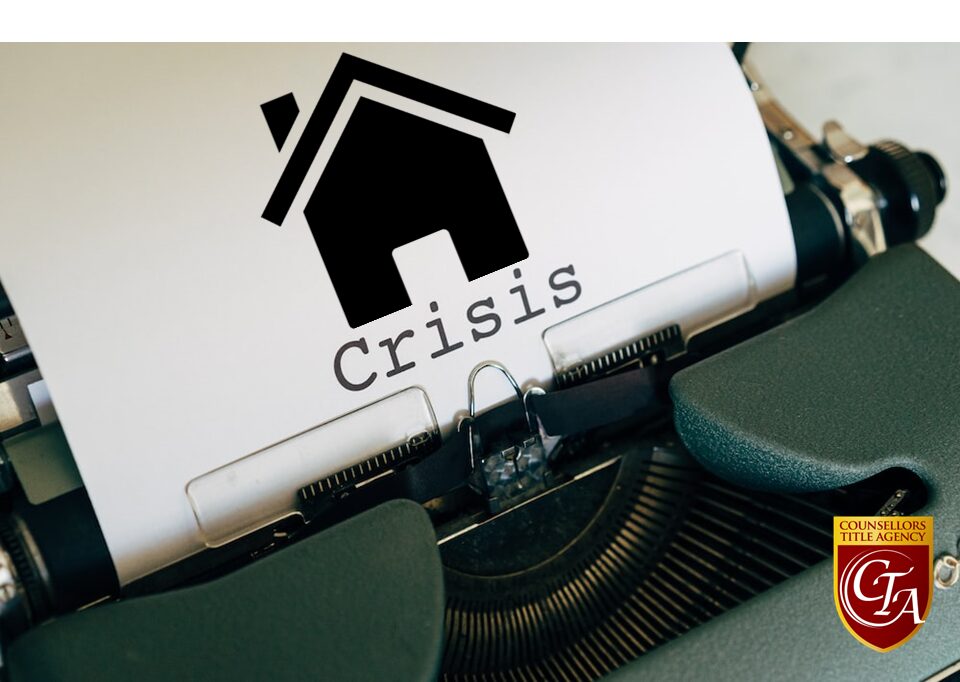 A typewriter with a paper showing the word 'Crisis' and a house icon above it.