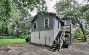 Exterior view of a two-story house with stairs leading to the upper floor.