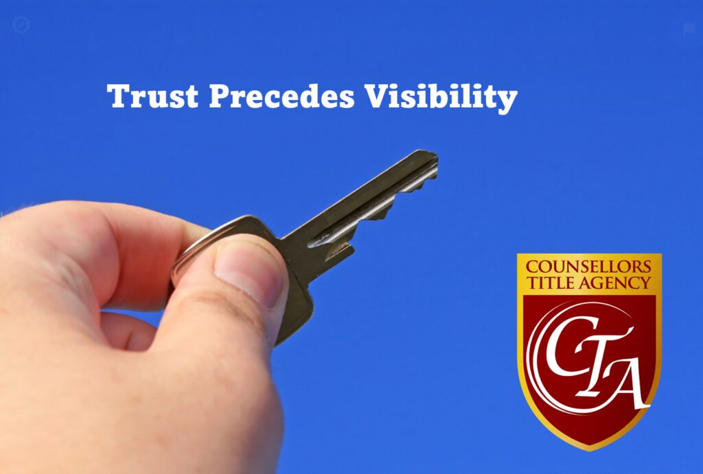 Hand holding a key against a clear blue sky with a trust-themed message.