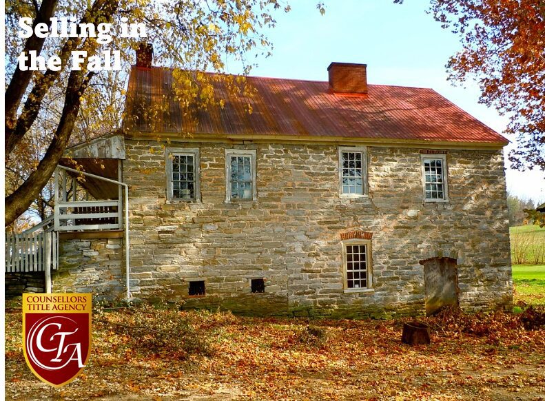 Historic stone house surrounded by fall foliage and leaves.
