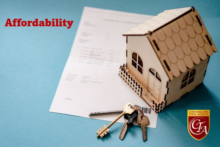 A miniature house model with keys on a contract document.