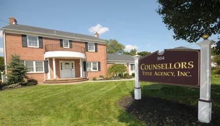 Brick building housing the Counsell Time Agency with a well-kept lawn.