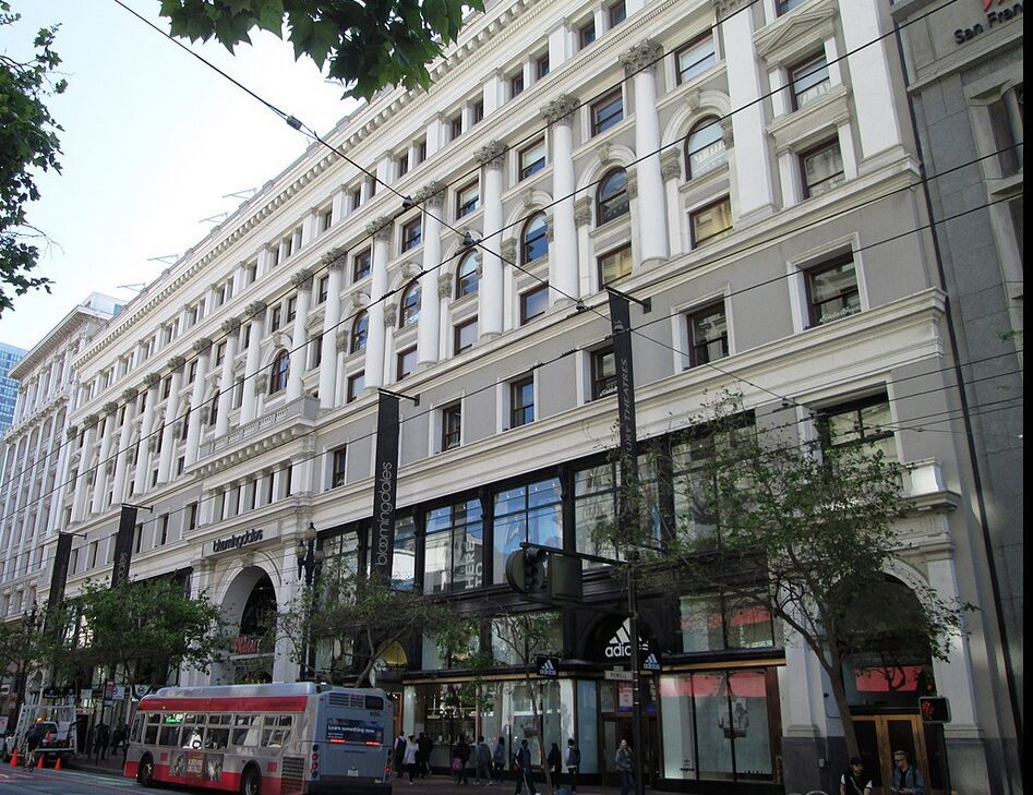 A large historic building with multiple windows and street-level shops.