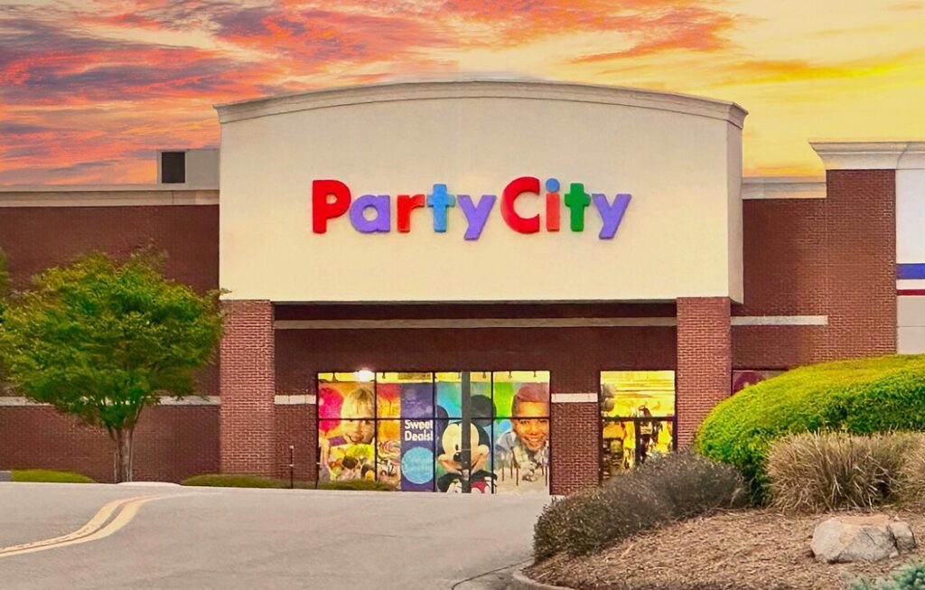 Party City store entrance at sunset with colorful signage.