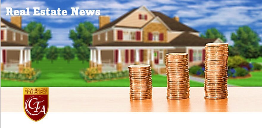 Stacks of coins with houses in background.