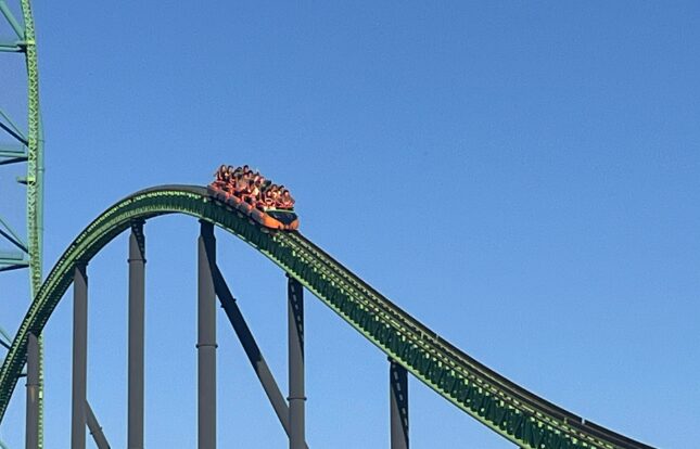Roller coaster descending with passengers onboard.