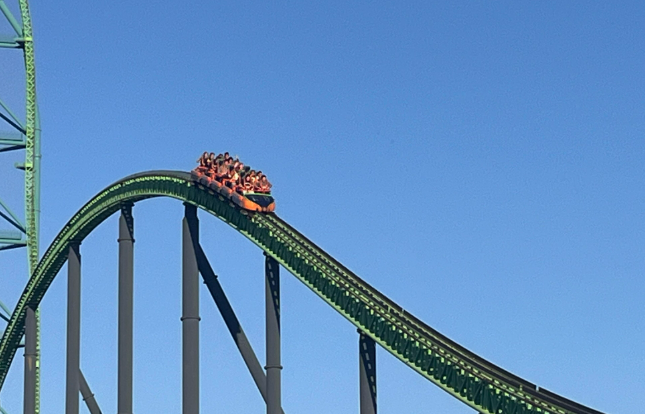 Roller coaster descending with passengers onboard.