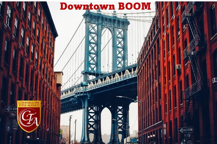 Blue suspension bridge framed by red brick warehouses