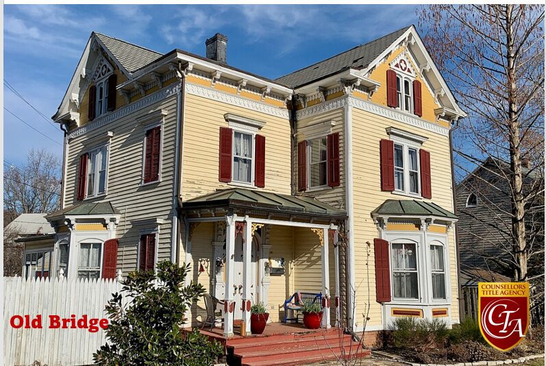 Yellow Victorian-style house with red shutters.