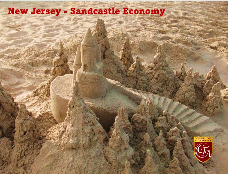 Intricate sandcastle with bridge on Jersey's sandy beach.