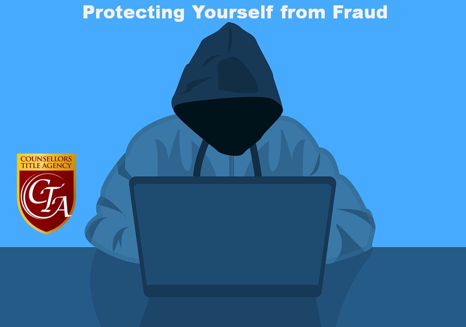 Hooded figure at computer preventing fraud.