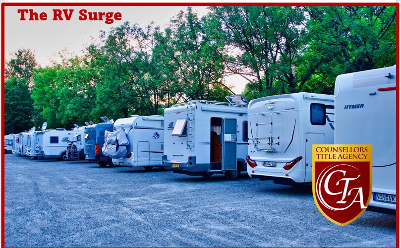 Row of RVs parked under trees.