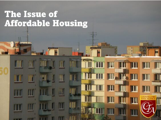Apartment buildings under a cloudy sky highlighting affordable housing issues.